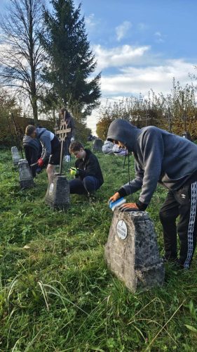 uczniowie klas 8a i 8b wraz z opiekunami postanowili uporządkować cmentarz wojenny nr 166 w Zalasowej